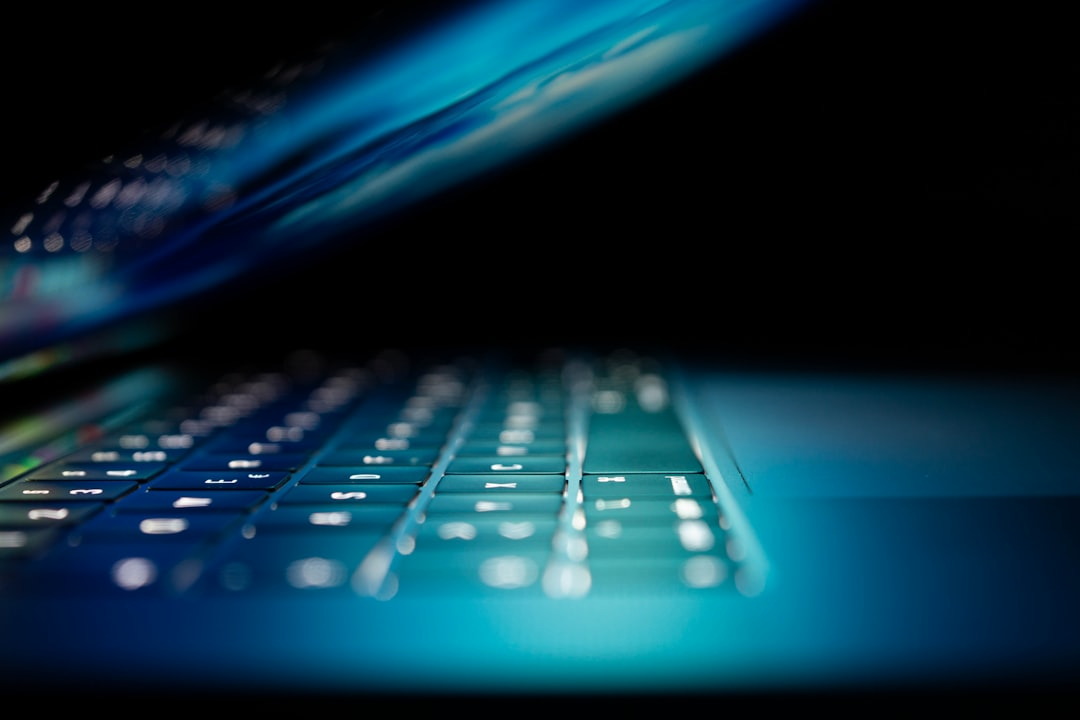 Eine Person tippt an einem Computer mit Code auf dem Bildschirm, was Softwareentwicklung symbolisiert